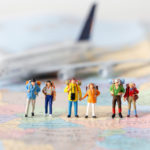 Miniature model team traveller model standing together on map, p